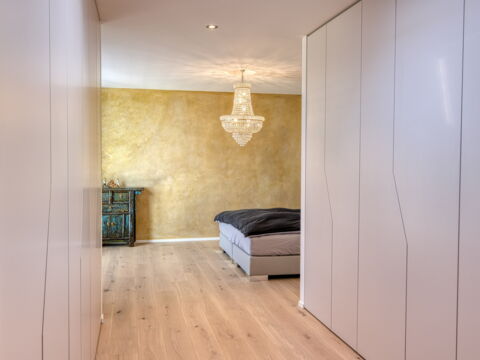 Bauleiter Innenausbau: Weisse Wandschränke mit Schlafzimmer im Hintergrund